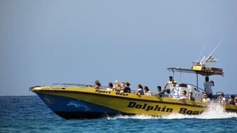 yellow speed boat with tourists
