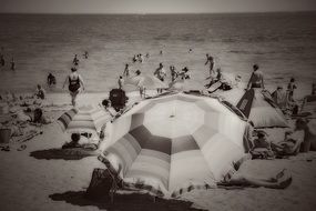 black and white photo of tourists on a sandy sunny beach