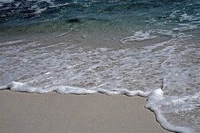 waves with foam on the beach
