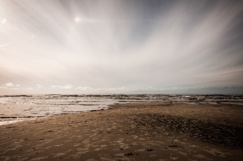 sandy beach near the Baltic Sea under the sky with white clouds