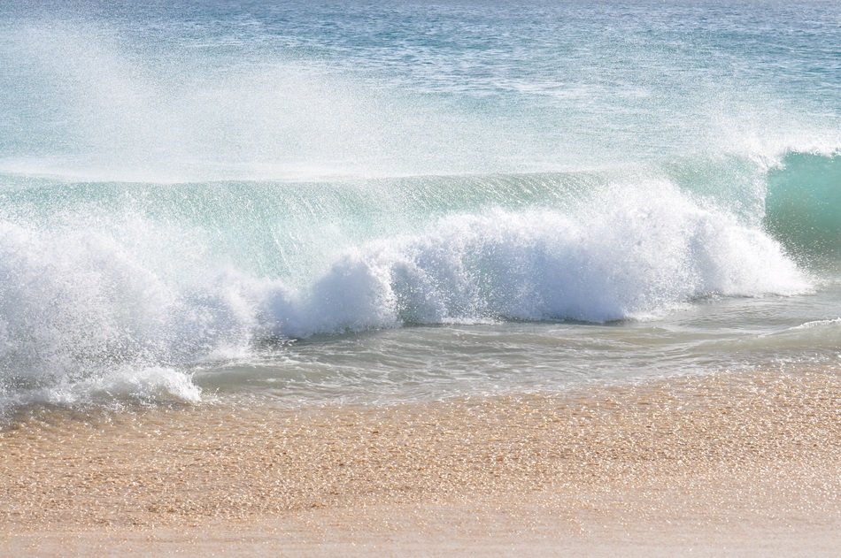 seascape of splashes from the waves on the sandy beach