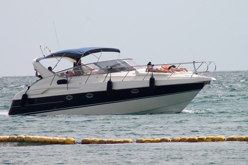 tourists sunbathe on the bow of a motor boat at sea
