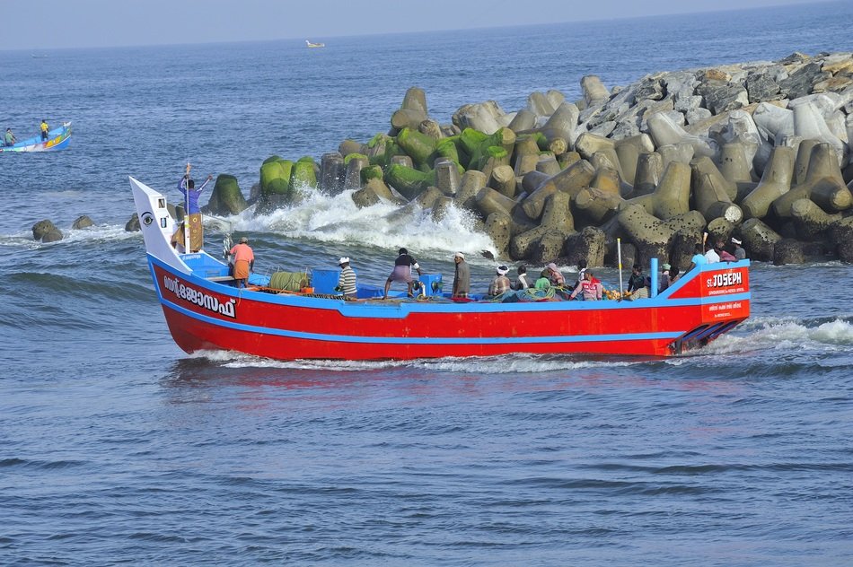 Fishing red Boat in the waves in the trivandrum