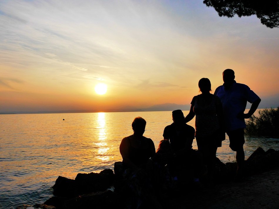silhouettes of people on the shores of Lake Garda