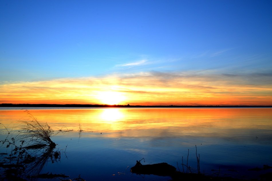 reflection of an orange sunset in calm water