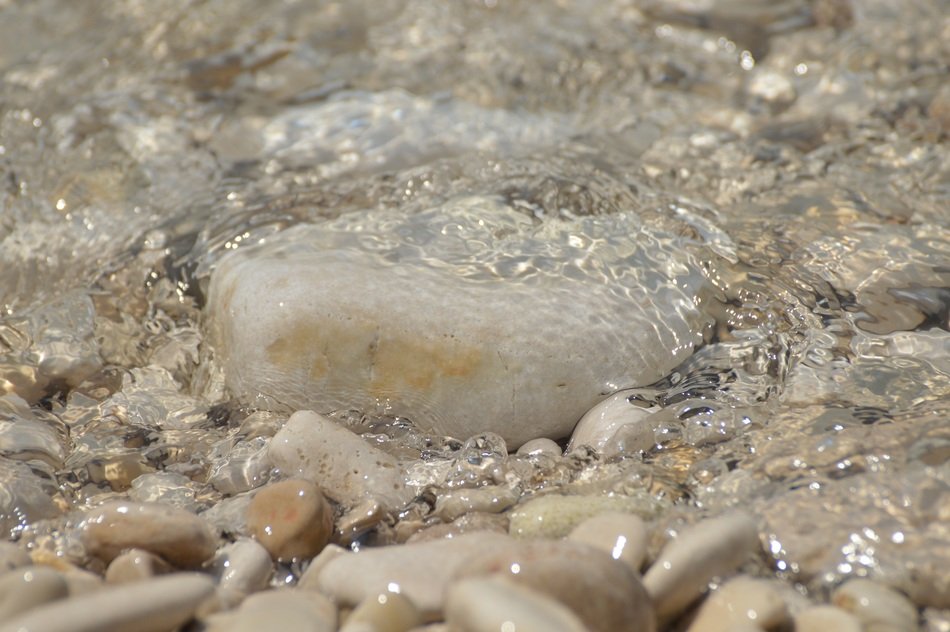 Colorful pebble beach under clear water