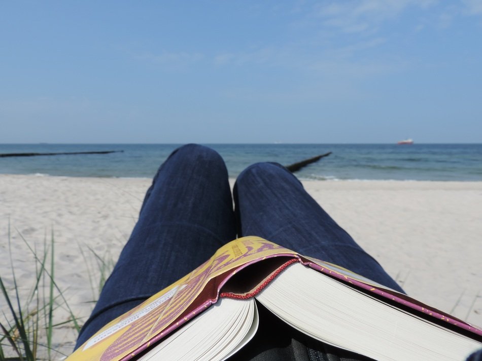 book on your knees, reading on the beach