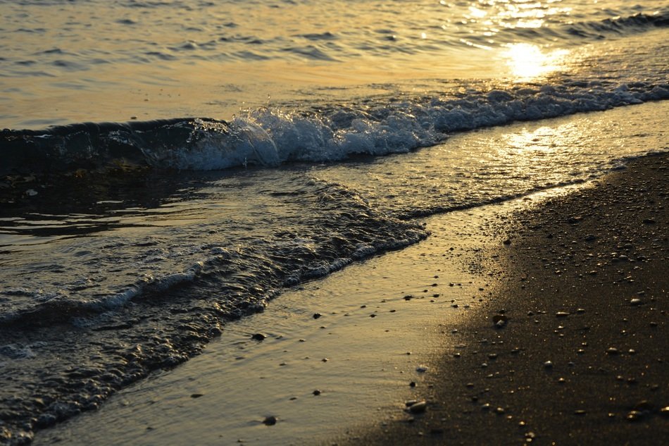 waves of sand surf at sunset close up