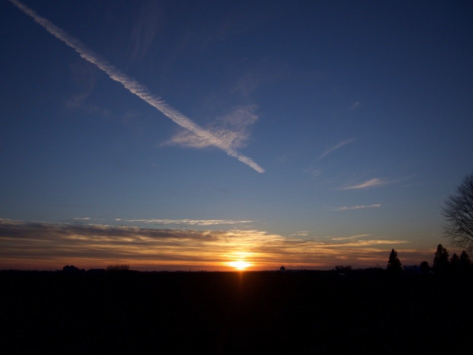 Beautiful sunset on the horizon and aircraft contrail in the sky