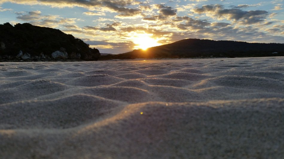 sandy beach in the sunset over the hills