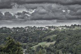 dark gray storm clouds over green forest