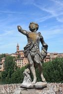 Statue on city background