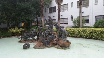 water statue near green bushes