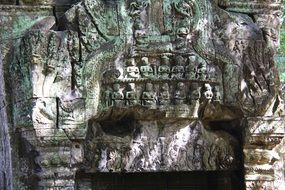 stone wall with statues in the temple of Ta Prohm