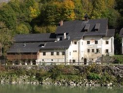 White house with a black roof on the river bank