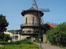 old stone windmill in park at summer