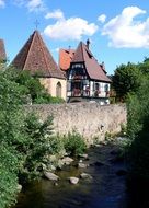 old houses along a stone wall by a stream