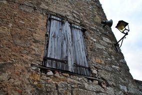 bottom view of old wood window on stone wall