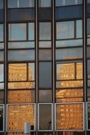 reflections in the windows of the facade of the building