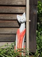 ceramic figure of a cat in front of a wooden house