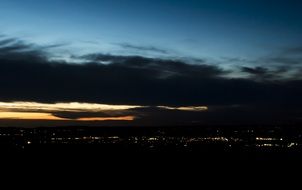 city lights against black clouds