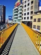 yellow city bridge among modern houses