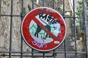 the painted sign with dogs is forbidden on a metal fence