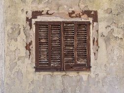 old window on the shabby facade of a building