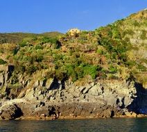 distant view of a yellow house on a hilltop on the coast