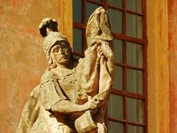 stone statue of a knight on a background of building