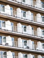 white painted balconies with metal fence at brown facade