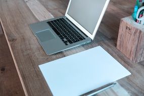 laptop and stationery on a wooden table