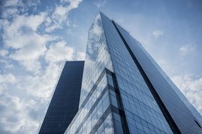 clouds reflected in the glass facade of a skyscraper