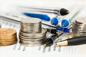 coins and pens on a paper