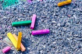 Colorful pieces of chalk on the asphalt road