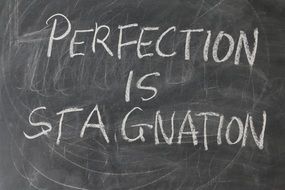 inscription on a school board - perfection stagnation