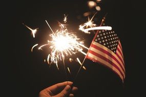 sparkler and american flag in a hand