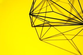 geometric metal structure on a yellow background