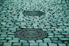 manhole covers on cobbled road