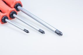 three screwdrivers with red handles