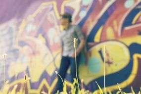 man leaning on the wall with graffiti