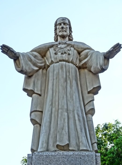 monument to jesus christ near green tree