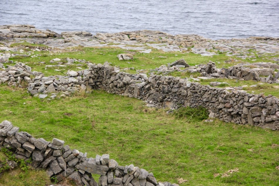 ancient stone wall green grass water ireland