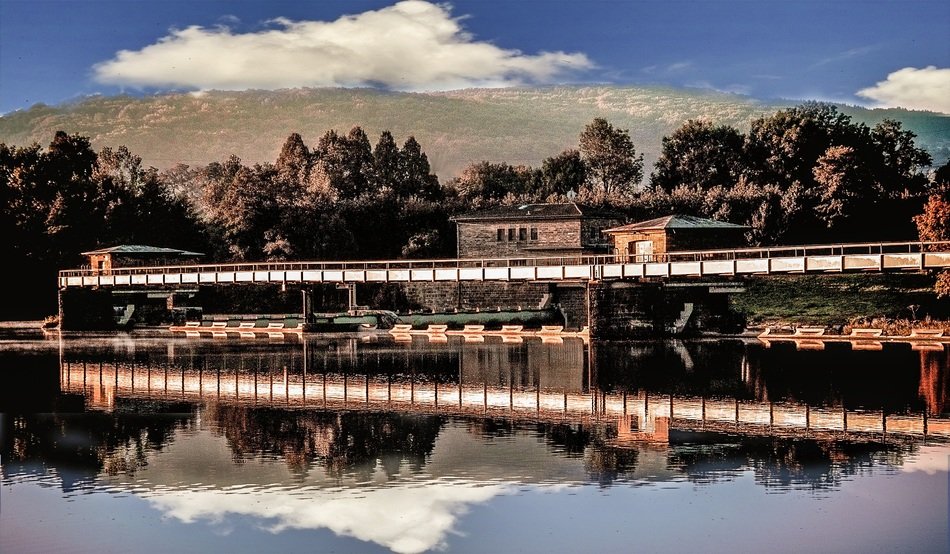 Beautiful river with the houses, plants and mountains on background