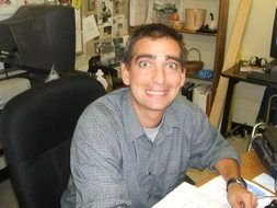 adult man with strange face at desk with papers