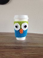 Crochet owl cup cozy in lime green and bright blue.