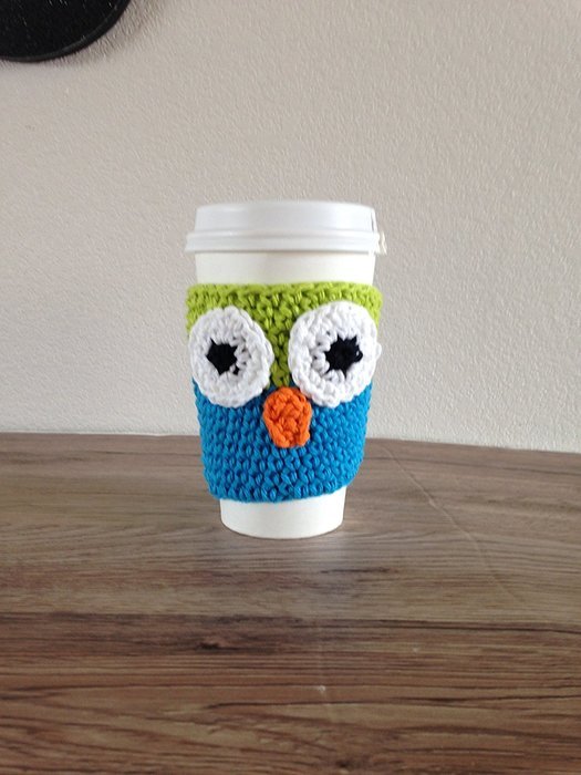 Crochet owl cup cozy in lime green and bright blue.