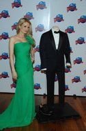 photo of a girl in a green dress by a manikin in a James Bond costume