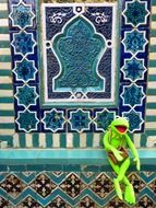 toy frog on the background of the Uzbek mosaic