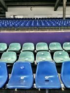 blue and green seats in the stands of the stadium